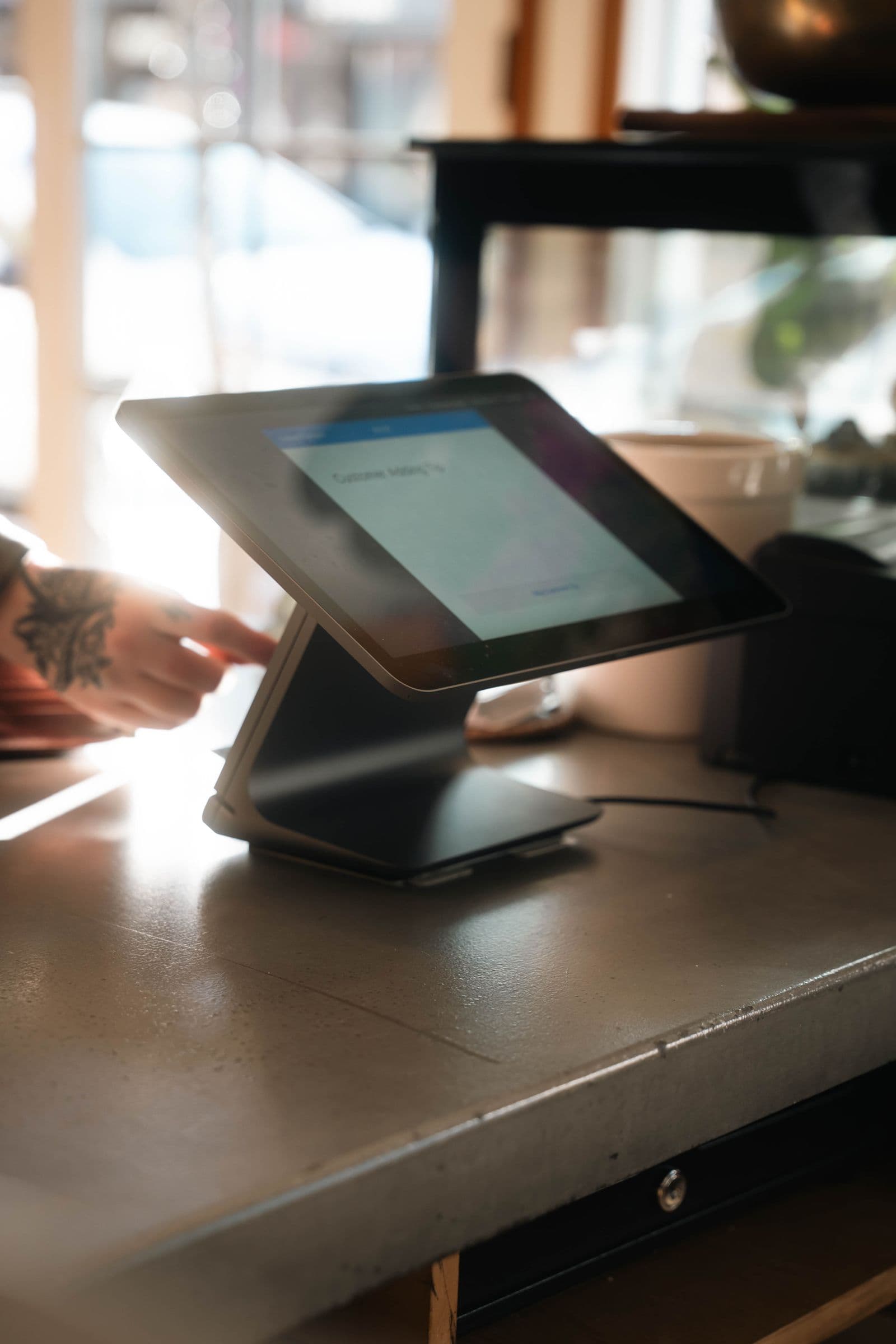 Tablette de caisse dans un café, illustrant un logiciel de réservation restaurant